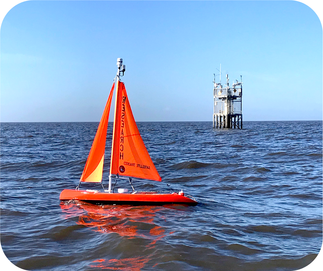 man holding on to autonomous sailboat